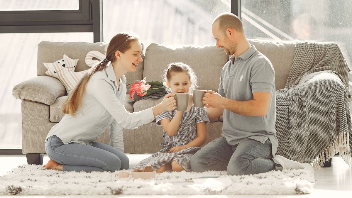 A joyful family enjoying quality time and coffee in a bright living room, symbolizing love and togetherness.